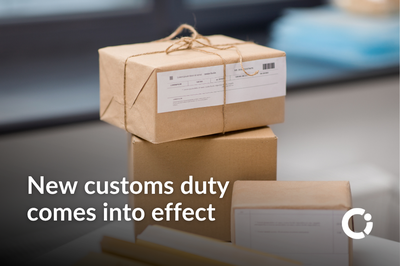 A stack of parcels with stickers and barcodes. Text reads: New customs duty  comes into effect